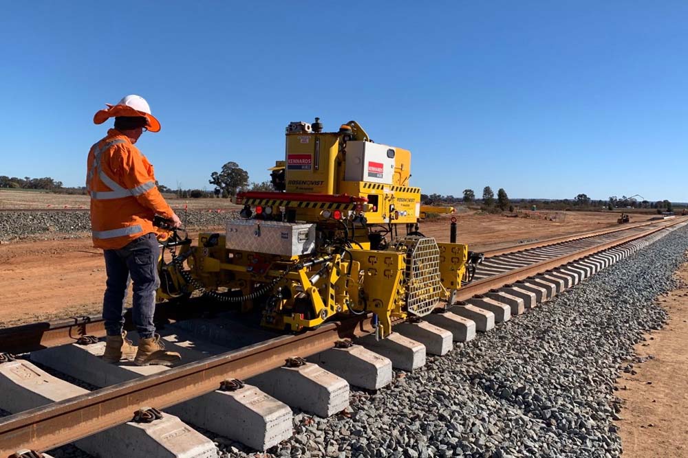 Worker using rail equipment on a rail line