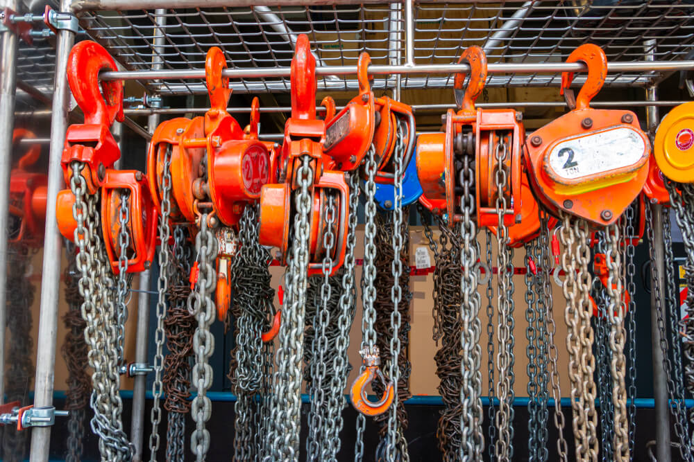 Material hoists lined up and attached to a cross-bar