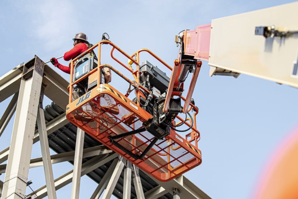 Kennards hire team member in a boom lift working on a hire roof
