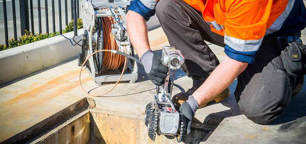 kennards hire team member testing and measuring water or oil